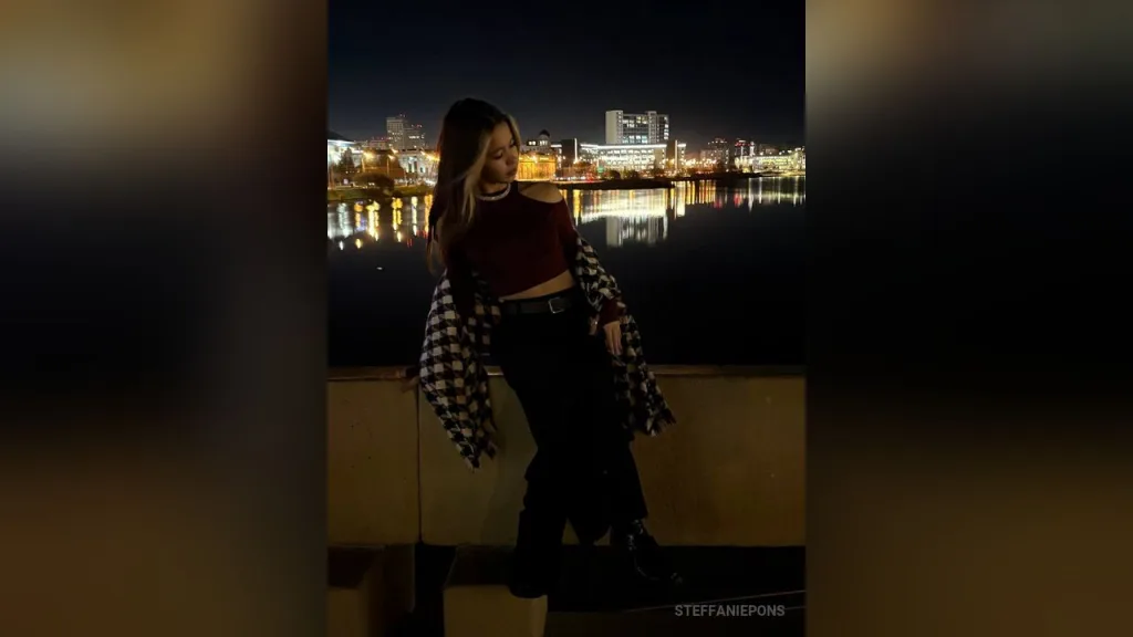 SteffaniePons poses with her hand against her cheek, wearing black clothing and sunglasses on top of her head.
