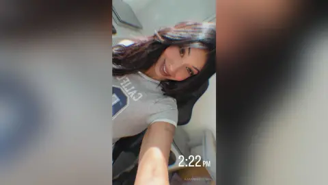 KarandeepSingh smiles while wearing a grey t-shirt, showing her long dark hair in a close-up selfie shot.