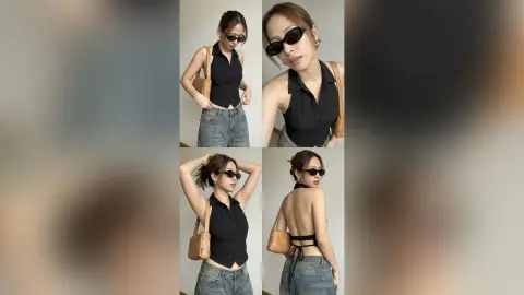 Stylish woman in a black button-down shirt and denim jeans posing in a minimalist indoor setting.
