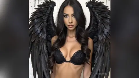 Beautiful brunette woman in black lace lingerie wearing large black angel wings in a moody studio setting.