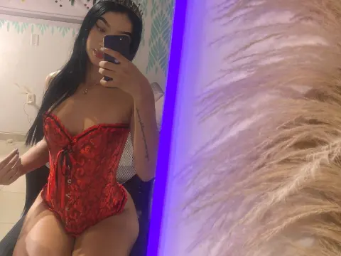 Young woman in a red lace corset bodysuit posing in a room with purple neon lighting.