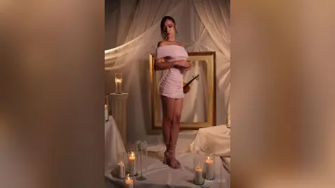 Elegant woman in a pink mini dress posing in a dreamy, candlelit room with soft aesthetic lighting.