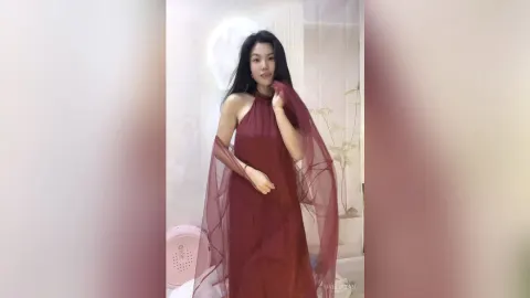 KireliaYan — KireliaYan poses in a long burgundy halter dress with sheer flowing fabric.