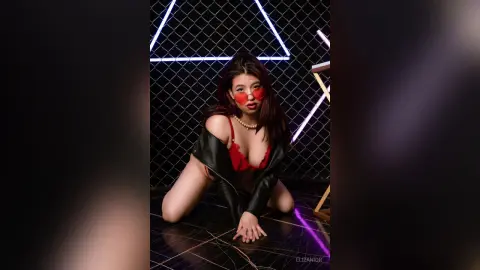 Stylish woman in red lingerie and heart sunglasses posing in a dark studio with neon light accents.