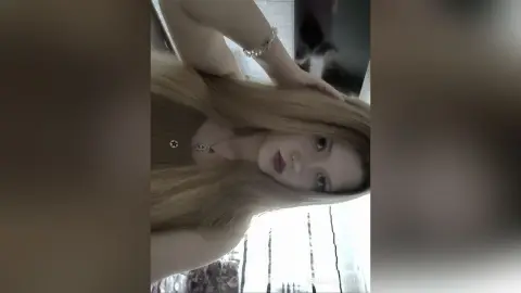 GemmaCiliberto poses with her long blonde hair, wearing a dark top and a silver necklace, looking directly at the camera.