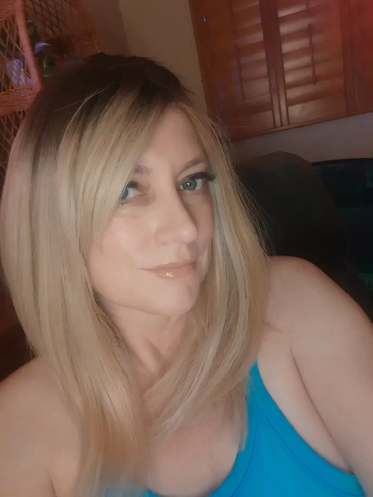 JenDoll poses with a close-up view of her face and blonde hair, looking directly at the camera with a soft smile.