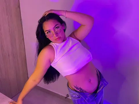 Young woman in white crop top and glasses posing under vibrant purple neon lighting.