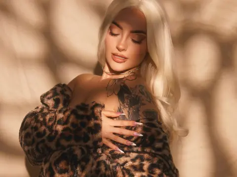 Blonde woman in a leopard print faux fur top posing with soft sunlight shadows for a glamorous aesthetic.