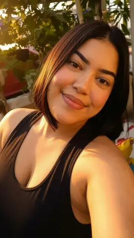 AlejaGoldk smiles wearing a black tank top with her dark hair styled in a blunt bob.