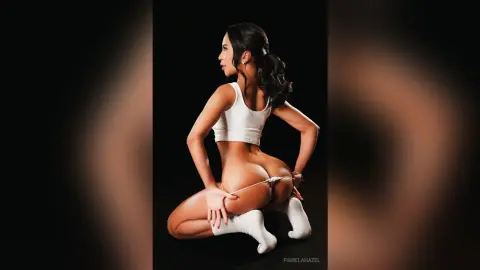 Fit woman in white crop top and socks posing in a studio setting with a confident mood.