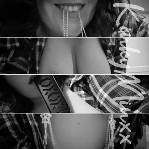 Smiling woman in a plaid shirt biting a silver necklace for a playful and flirtatious mood.