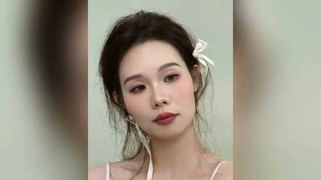 lingzi — lingzi looks at the camera with her dark hair styled in messy buns with white bows.