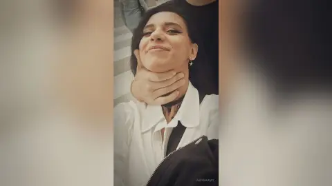 Smiling woman in a white blouse and black choker laughing during a playful moment outdoors.
