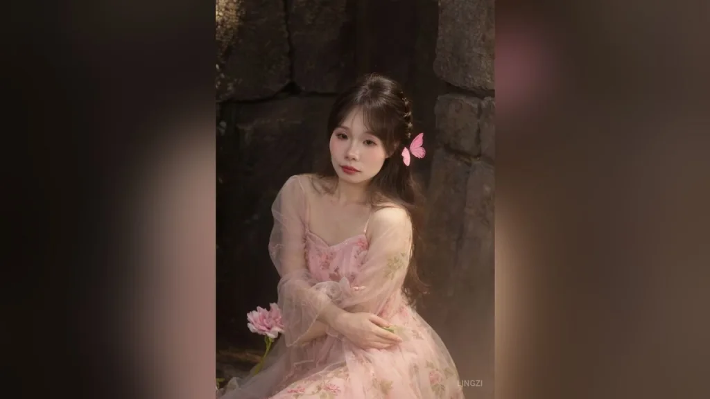 lingzi — lingzi poses in a pink floral dress with butterfly hair accessories against a dark stone background.