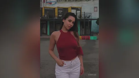 EmmyLee — EmmyLee poses outdoors in a red halter top and white pants.