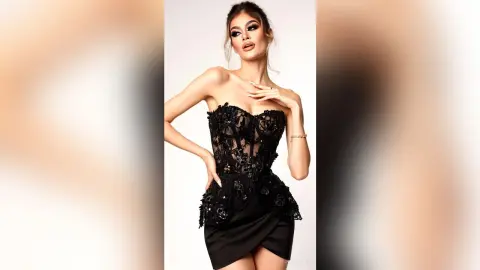 Elegant woman in a black lace strapless cocktail dress posing against a white studio background.