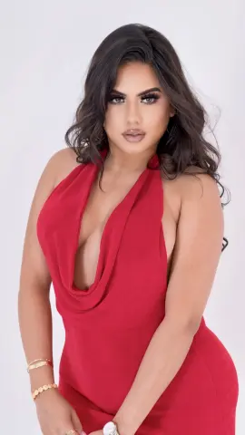 Leialeen — Glamorous woman in a plunging red halter dress posing against a white background for a chic fashion look.