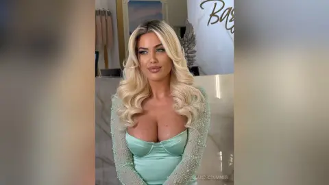 Glamorous blonde woman in a mint green sequin gown posing in a luxury marble interior.