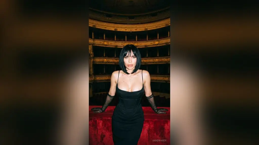 SandraBex — Elegant woman in a black evening dress and sheer gloves posing in a luxurious vintage opera house.