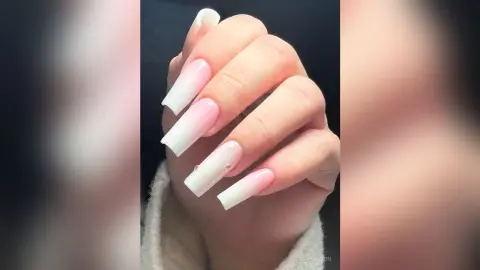 Close-up of long pink and white ombre coffin shaped acrylic nails with subtle rhinestone nail art.