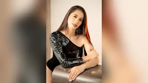 ValentinaHoffman poses in a black long-sleeved mesh bodysuit with silver reflective sequins, leaning against a dark textured surface.