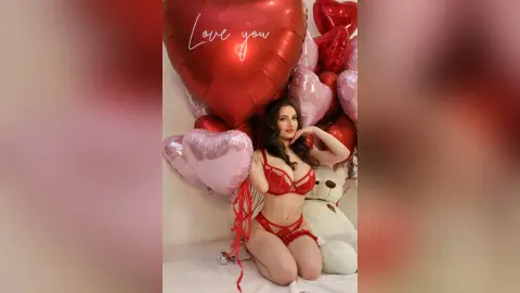 Woman in red lace lingerie posing with heart balloons for a romantic Valentine's Day mood.