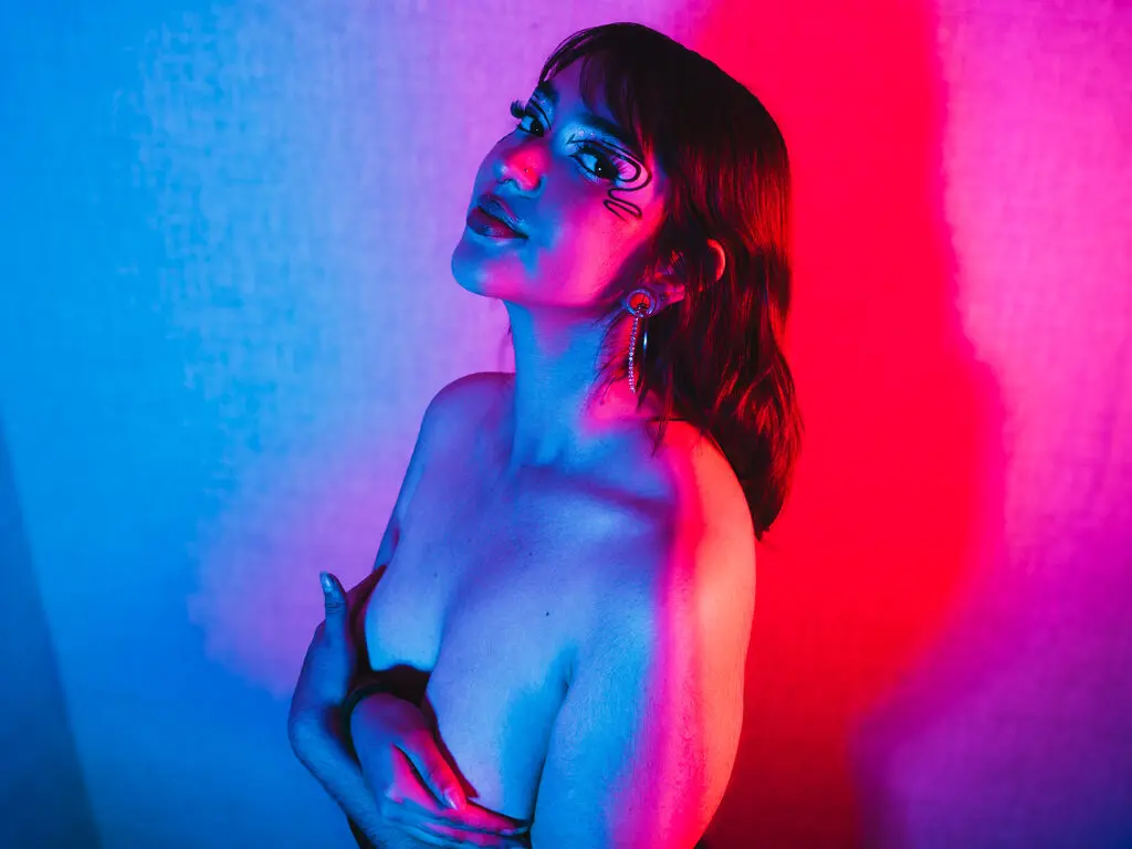 Young woman in moody blue and pink neon lighting posing in a cinematic, artistic portrait.