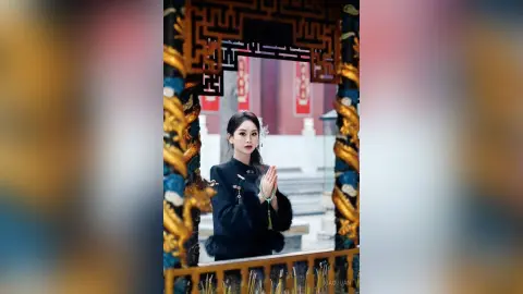 Elegant woman in traditional black Hanfu posing gracefully in a classic Chinese courtyard setting.