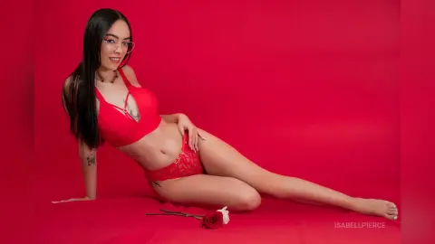 Smiling woman in red lingerie and glasses reclining on a red background for a romantic studio photoshoot.