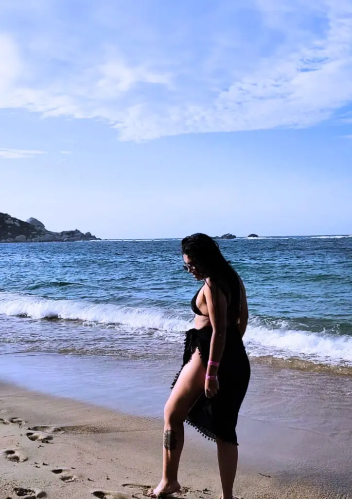 GiselOrtiz poses with her arms raised, wearing a black and white checkered lace bralette.