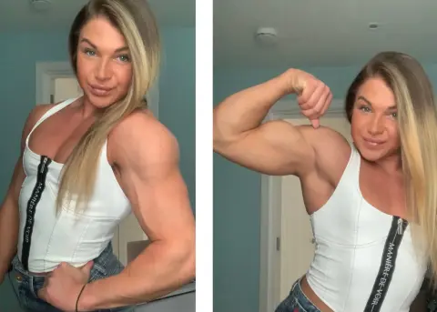 British_EmJess flexes her muscular bicep and shoulder while wearing a white zip-up tank top and denim jeans.