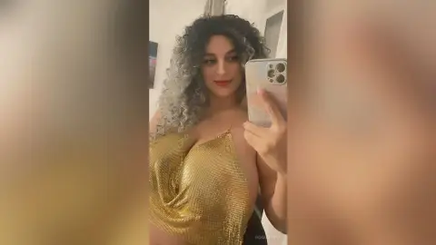 Curvy woman with curly hair wearing a glamorous gold sequin halter top for a chic evening look.