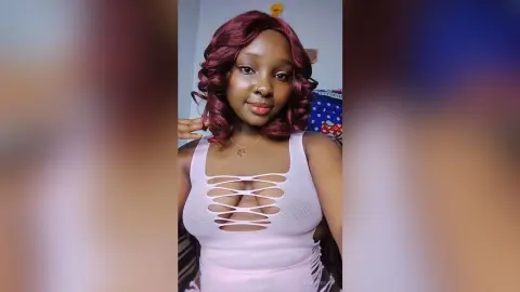 JenniferJoe wears a white cut-out tank top that shows her cleavage, posing against a plain background.