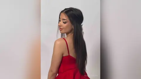 Elegant woman in a red satin slip dress posing against a white background with a soft, glamorous mood.