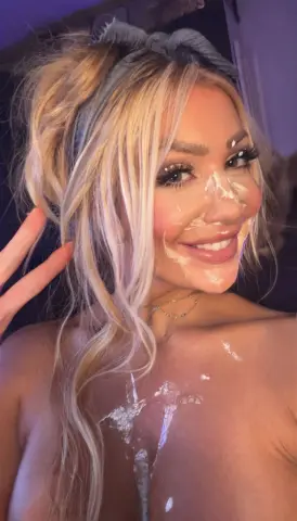 Lettie_Looner smiles with white cream or lotion smeared on her nose, cheeks, and chest, showing her blonde hair and bare shoulders.