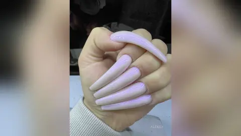 Close-up of long lavender almond-shaped acrylic nails on a hand with a soft aesthetic mood.