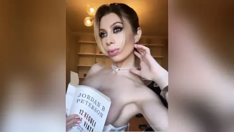 Elegant woman in a white pearl necklace reading a book in a warm, softly lit indoor setting.