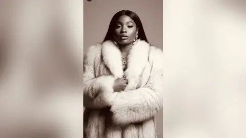 Elegant Black woman in a luxurious white faux fur coat posing with a sophisticated mood in a studio setting.
