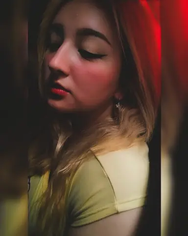 Katiee_and_sharon with long blonde hair and red lipstick poses in a yellow top.