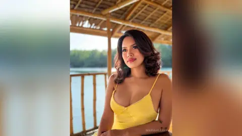 Beautiful woman in a yellow sundress relaxing under a bamboo gazebo by a serene lake at sunset.