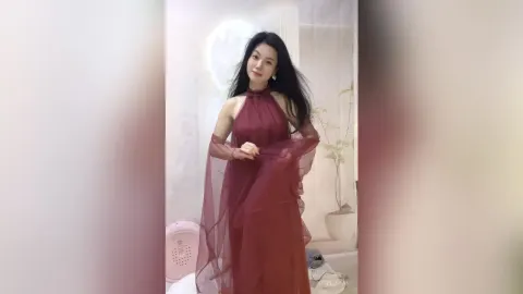 KireliaYan — KireliaYan poses in a long, sheer burgundy halter dress with her long dark hair flowing down.