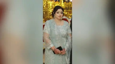 Elegant woman in a shimmering silver sequined lehenga posing at a festive formal event.