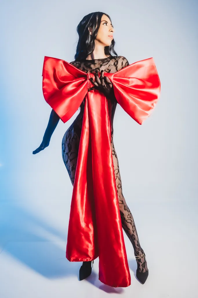 AilynHoney — AilynHoney poses in a black lace bodysuit featuring a massive red satin bow on the chest.