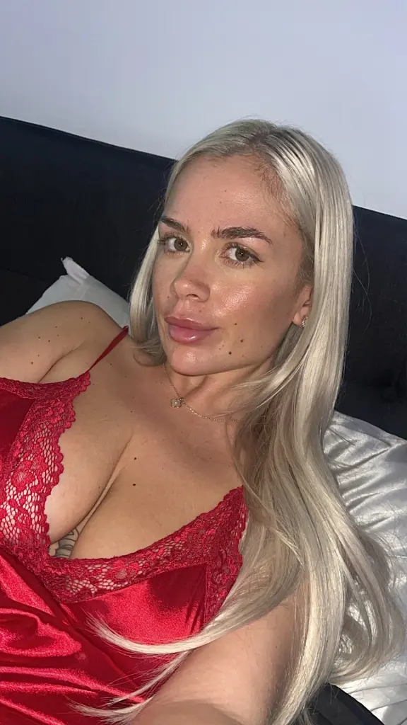 BritishBlondeBabydoll poses with her long blonde hair down, wearing a light blue tank top that shows off her cleavage.