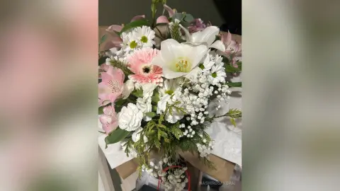 Beautiful bouquet of pink gerbera daisies, white lilies, and baby's breath in a romantic floral arrangement.