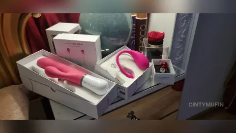 Pink wellness products and lifestyle accessories displayed in white packaging on a mirrored vanity surface.