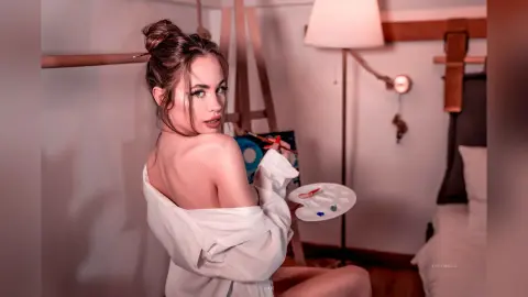 EvelynMills looks over her shoulder while wearing an open white shirt that exposes her bare back and shoulders.