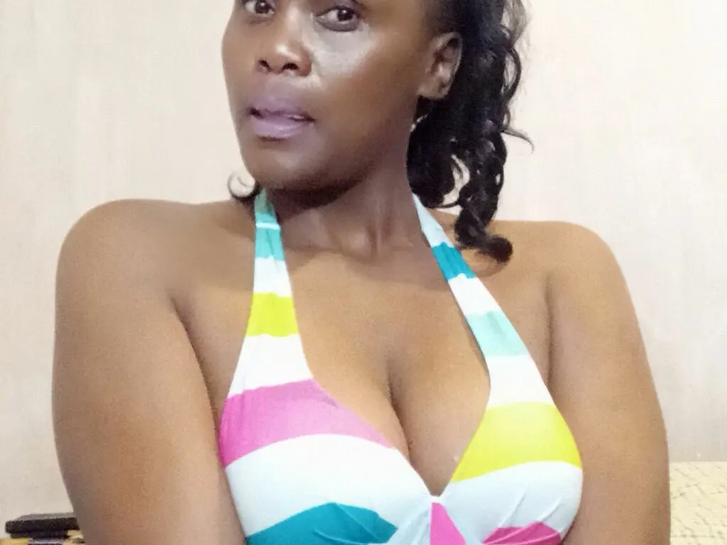 Beautiful woman in a colorful striped halter bikini top relaxing in a bright indoor setting.