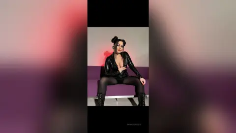 Glamorous woman in a shiny black bodysuit and tights posing confidently against a purple studio background.
