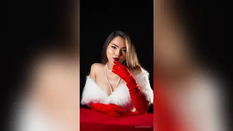 RosieThomas — Elegant woman in red gloves and white faux fur outfit posing against a dark background with a glamorous mood.